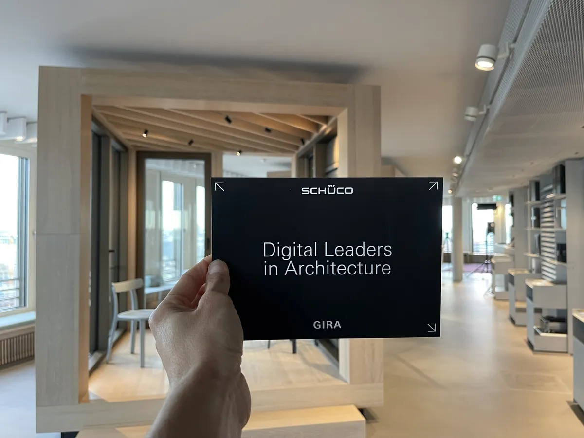 Moderationskarte »Digital Leaders in Architecture« mit den Logos von Schüco und Gira, dahinter der Schüco Showroom Hamburg
