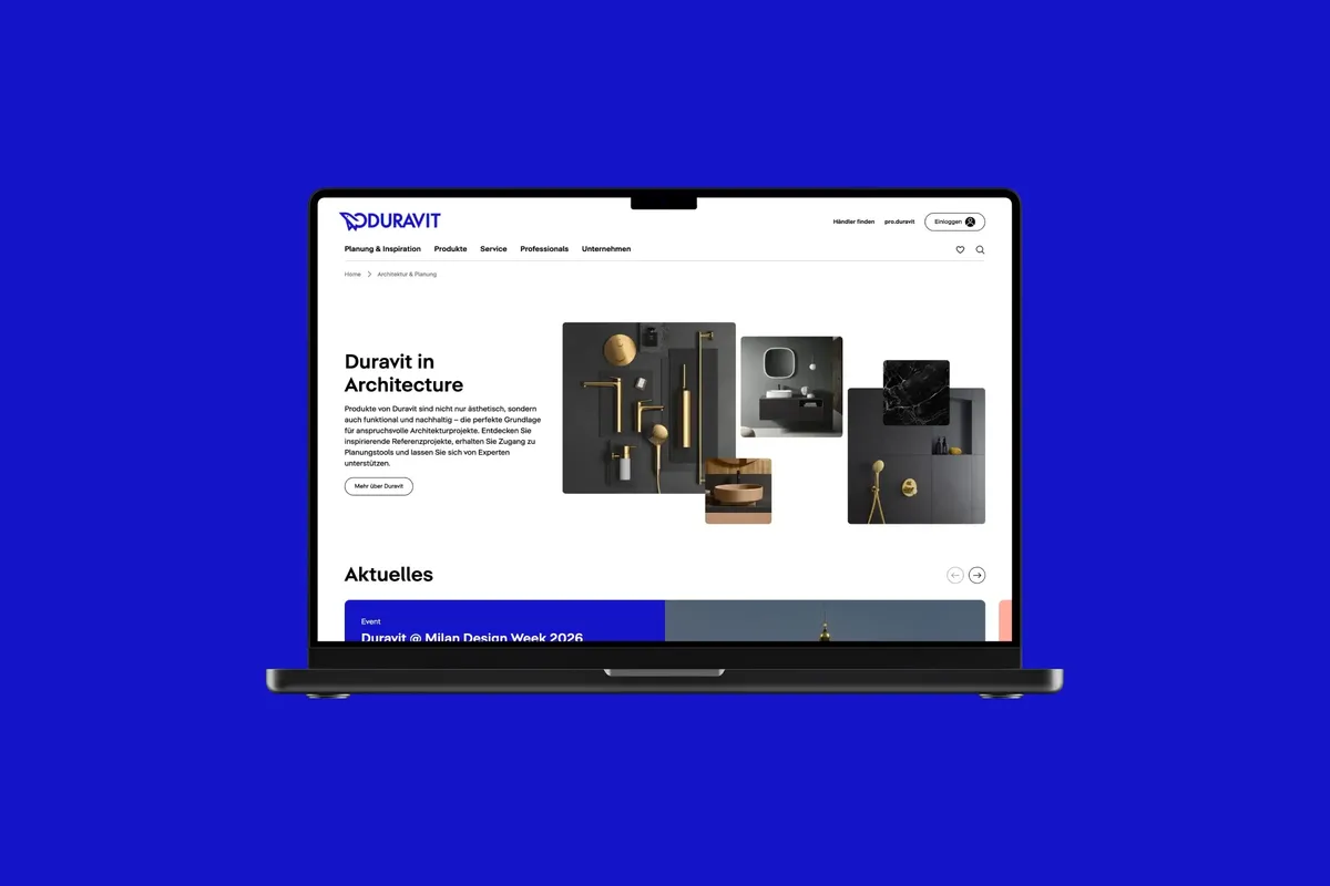 Laptop mit der Duravit-Landingpage »Duravit in Architecture«, Produktcollage und Bereich »Aktuelles« auf blauem Hintergrund