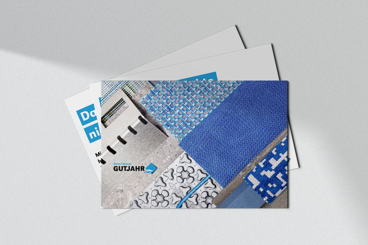 Gutjahr-Postkarten mit einer Collage aus Oberflächen und Texturen in Blautönen und dem Gutjahr-Logo