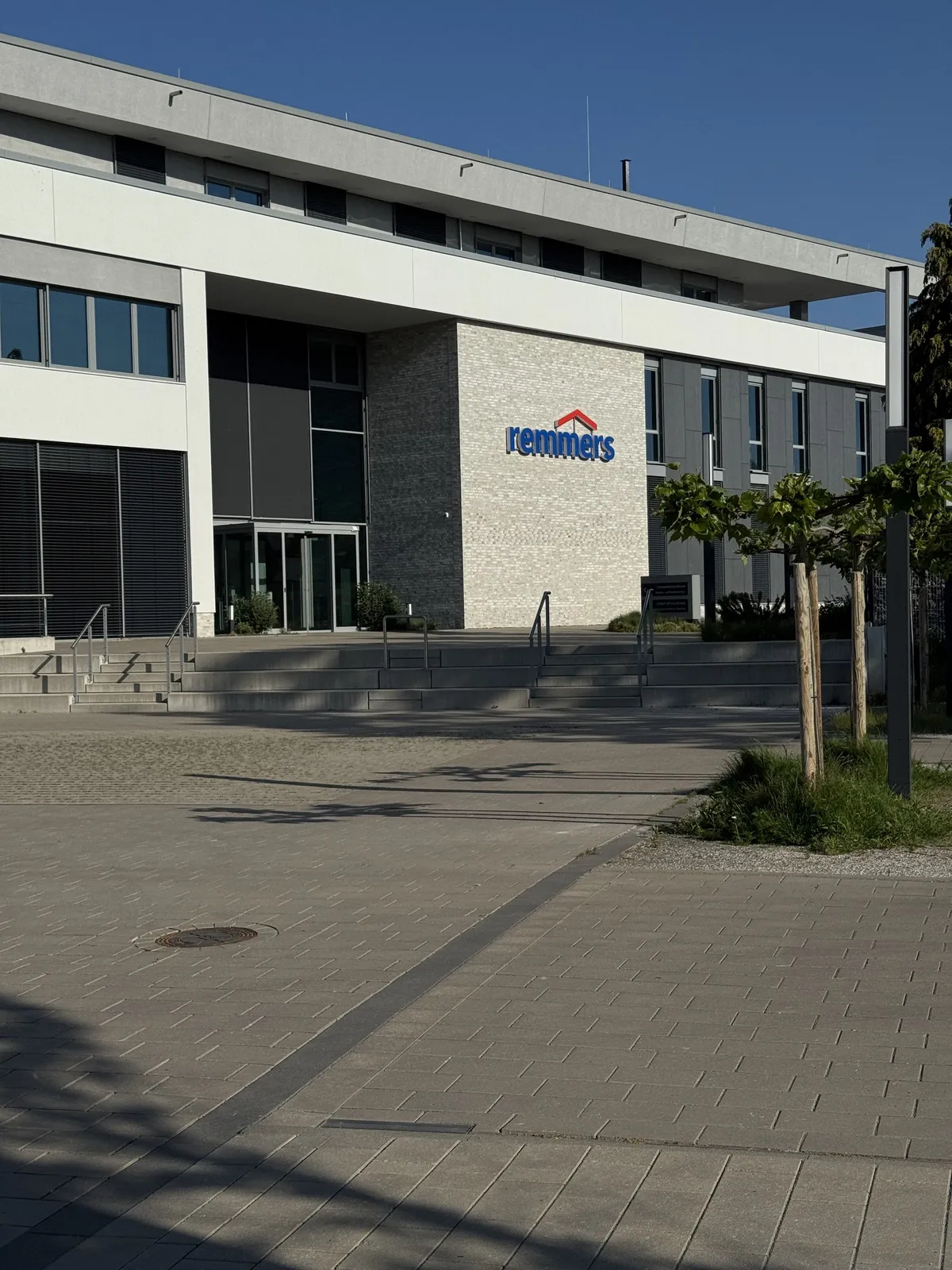 Zentrale von Remmers mit Logo über dem Eingang an einem sonnigen Tag