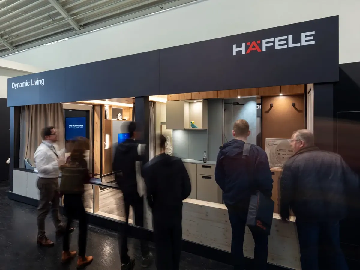 Besucher betrachten interaktive Präsentation des Häfele 'Dynamic Living' Konzepts mit digitaler Produktvorführung auf der BAU 2025