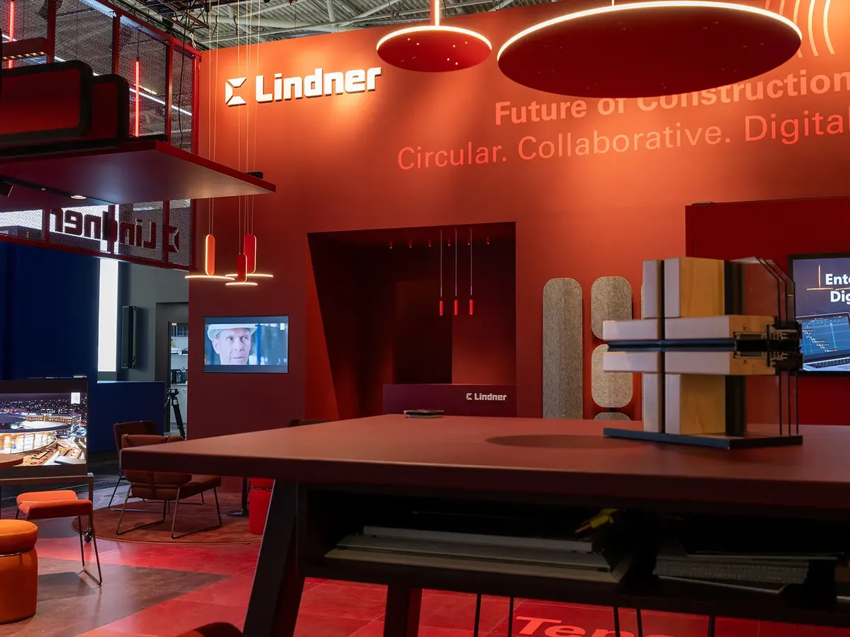 Lindner Group Messestand in kräftigem Rot gehalten mit LED-Streifen und Streckmetall, präsentiert 'Future of Construction' Konzept