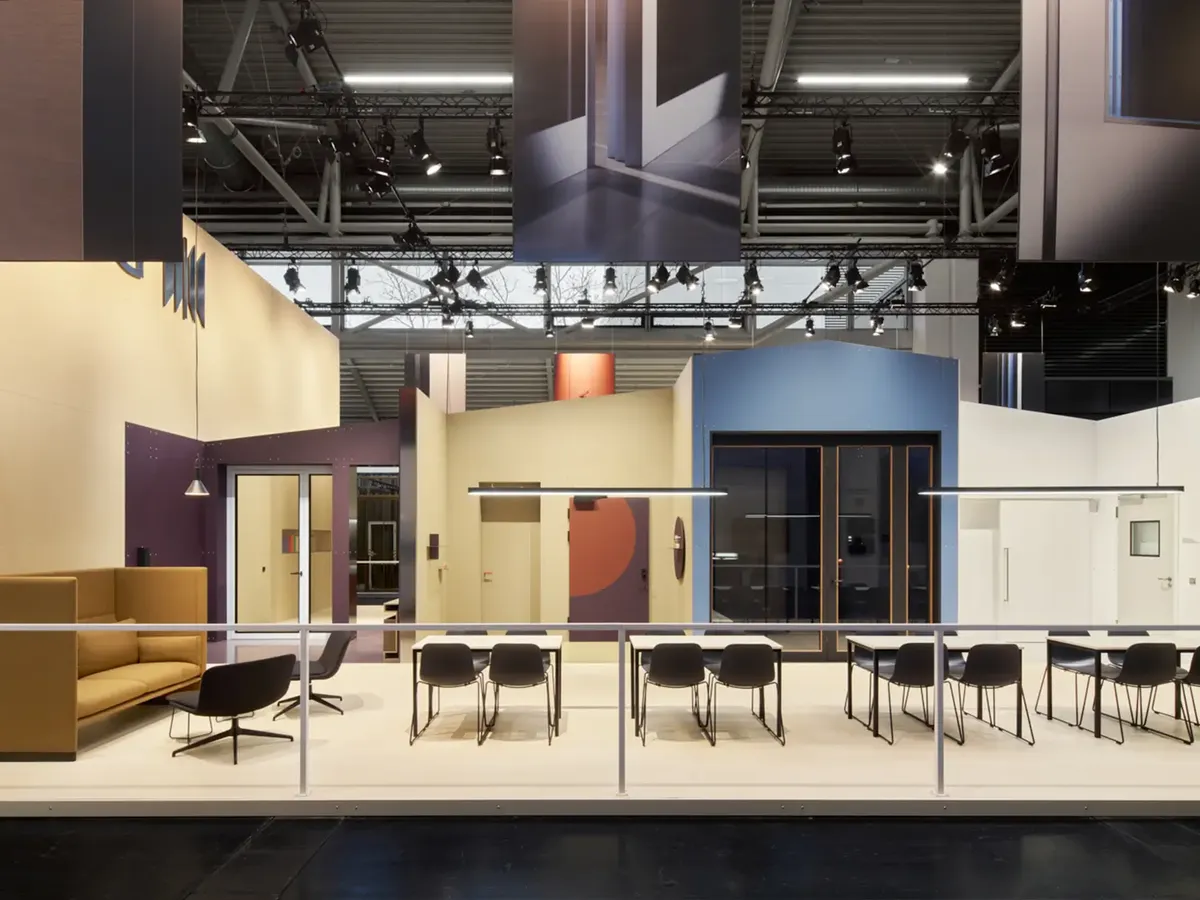 Westag offener Ausstellungsbereich mit verschiedenfarbigen Wandelementen und integrierten Türmustern, schwarze Stühle in Reihe angeordnet