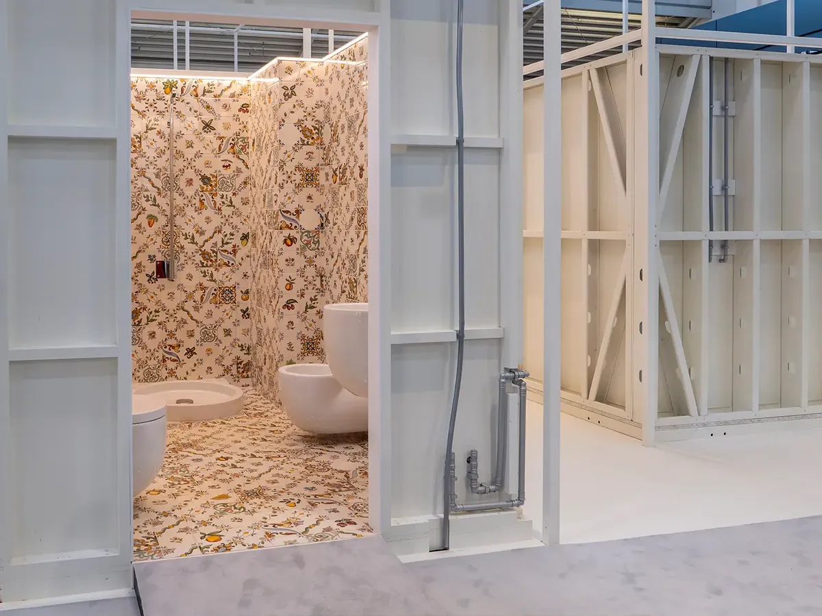 MODS Sanitärbox auf der BAU 2025: Badezimmer mit ornamentalen Fliesen in Beige und Weiß, moderne Sanitärobjekte in minimalistischem Design
