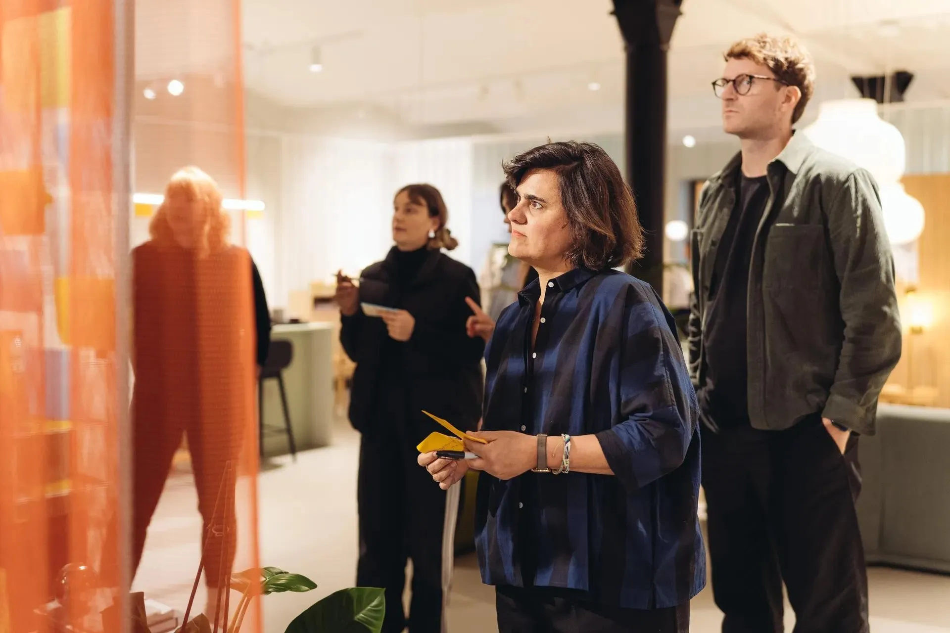 Four people standing together in a showroom, talking