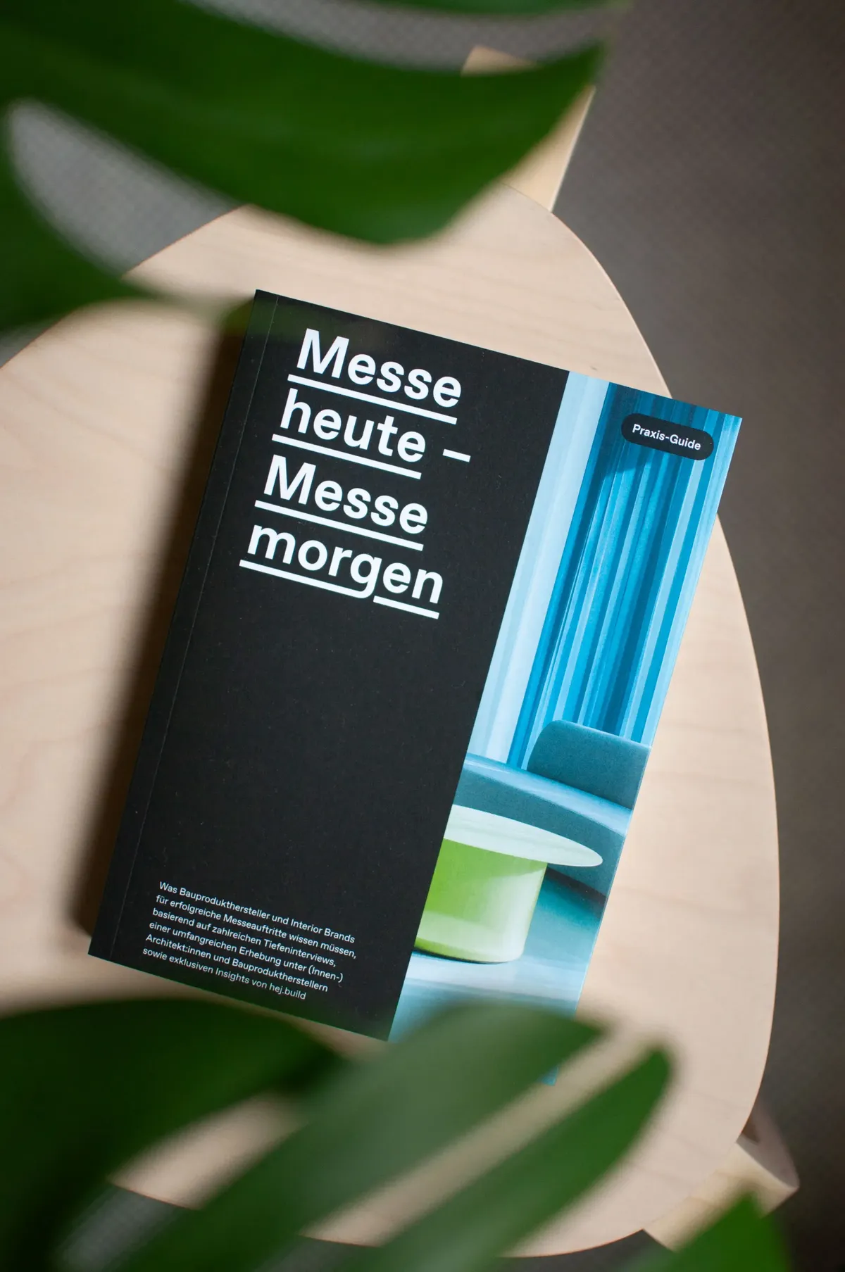 Praxis-Guide »Messe heute – Messe morgen« auf einem Holztisch, zwischen Blättern fotografiert